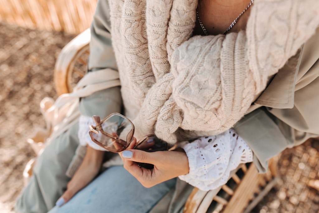 Woman Sitting on Chair Holding Sunglasses